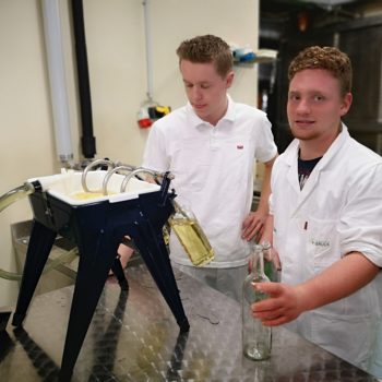 Schüler füllen Met in Flaschen ab